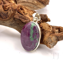 Load image into Gallery viewer, Anyolite Ruby in Zoisite Oval Cabochon Silver pendant is lying on a branch