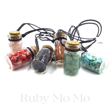 Load image into Gallery viewer, small gemstones in a bottle being made into a necklace with leather chain