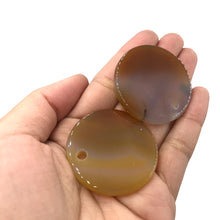 Load image into Gallery viewer, Two Carnelian Circle pendants on a hand
