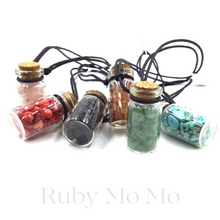 Load image into Gallery viewer, Small Gemstones in a bottle and being made into a necklace with leather
