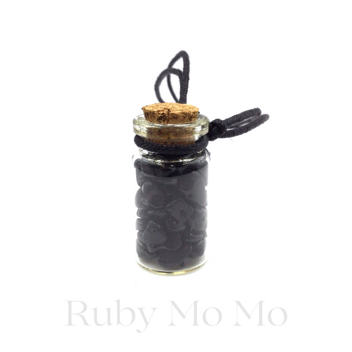 Black Onyx small stones in a bottle being made into a necklace with leather chain